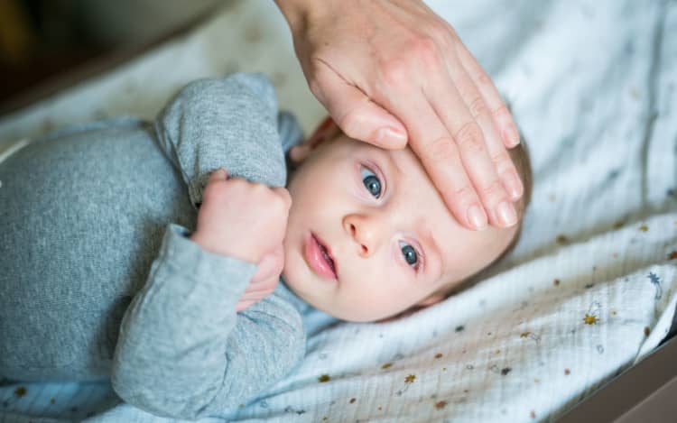 Checking the temperature of 3 month old baby boy.