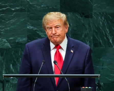US president Donald Trump in dark suit and red tie.