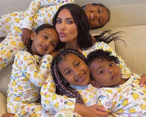 The Kardashian family grouped in a hug on a sofa wearing matching pyjamas