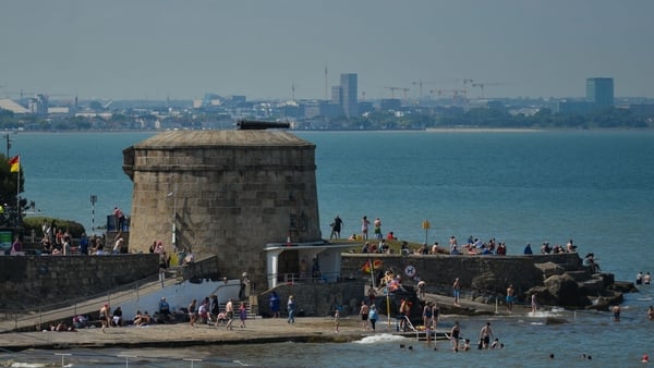 A tower is seen in the background as beachgoers enjoy fine weather